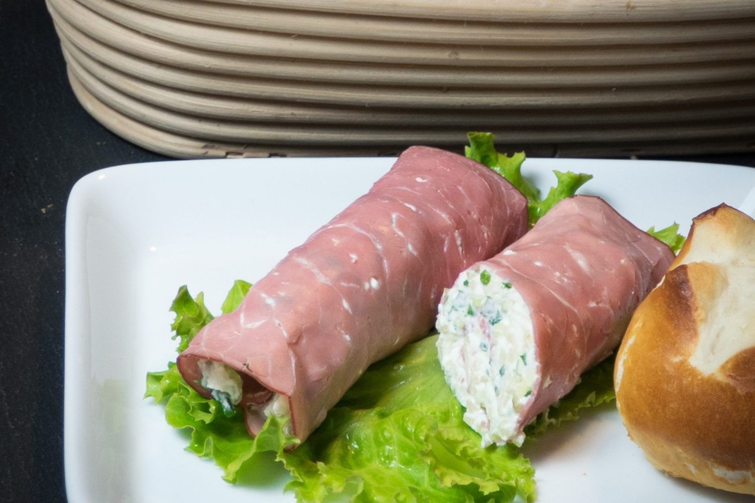 Vitaminröllchen aus Rindersaftschinken, gefüllt mit Apfel-Topfen-Creme und Kresse, serviert auf Blattsalat.
