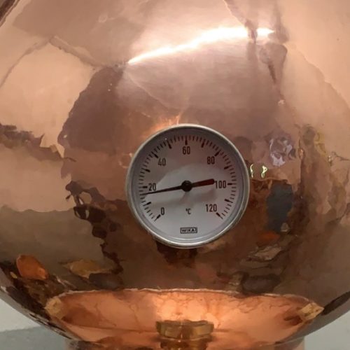 Kupferkessel mit Thermometer in der Brennerei des Eggenhofs – traditionelle Edelbrandherstellung in Tirol